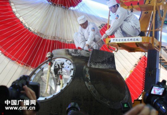 工作人員進(jìn)入返回艙,取出艙內(nèi)物品(中廣網(wǎng)記者劉夢 攝)